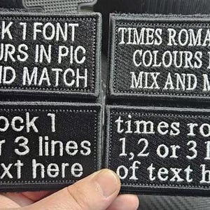 May include: Four black fabric patches with white text. The top two patches show the text "BLOCK 1 FONT COLOURS IN PIC MIX AND MATCH" and "TIMES ROMAN FONT COLOURS IN PIC MIX AND MATCH". The bottom two patches show the text "block 1 1,2 or 3 lines of text here" and "times roman 1,2 or 3 lines of text here".