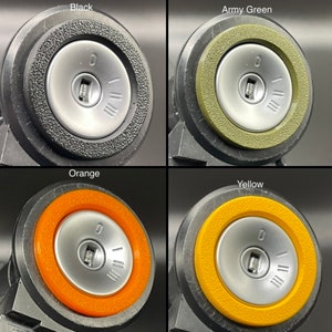 May include: Four key fob covers in different colors: black, army green, orange, and yellow. Each cover has a silver keyhole and a textured outer ring.