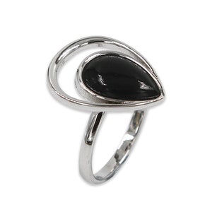 Può includere: Un anello d'argento con una pietra nera a forma di goccia. La pietra è incastonata in una fascia d'argento a spirale e aperta. La fascia dell'anello è liscia e lucida, creando un'estetica elegante e moderna. L'anello è mostrato su sfondo bianco.