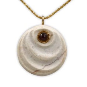 May include: A gold necklace with a circular pendant. The pendant has a swirling, off-white pattern and a small, dark red gemstone set in a gold bezel. The chain is a twisted rope design. The necklace is a piece of jewellery.