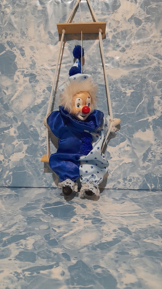 POUPEE CLOWN PORCELAINE ET TISSU A GRELOT SUR BALANCOIRE H 65