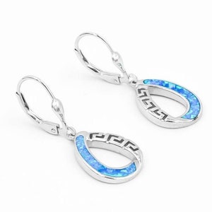 以下が含まれることがあります： 青いオパールの涙の形をしたデザインのシルバー製のドロップイヤリングのペア。涙はギリシャの鍵のパターンで縁取られています。