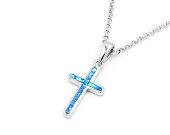 Könnte beinhalten: Eine silberfarbene Halskette mit einem Kreuzanhänger. Das Kreuz hat einen blauen Opal-Einsatz und hängt an einer feinen Kette. Der Anhänger ist ein schlichtes, elegantes Design.