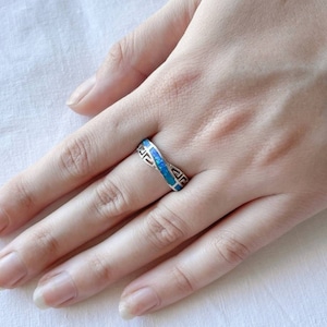 Könnte beinhalten: Ein silberner Ring mit einem blauen Opal-Inlay und einem griechischen Schlüsselmuster.