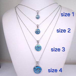 K&ouml;nnte beinhalten: Vier silberfarbene Halsketten mit runden Anh&auml;ngern, die eine blaue Spirale enthalten. Die Anh&auml;nger sind nach Gr&ouml;&szlig;e sortiert und mit size 1, size 2, size 3 und size 4 beschriftet, wobei die Kettenl&auml;nge zunimmt, um die verschiedenen Gr&ouml;&szlig;en zu zeigen.