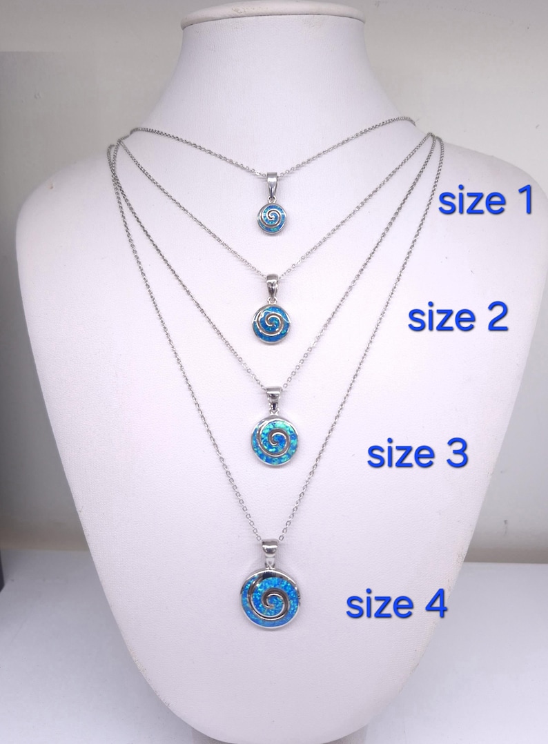 K&ouml;nnte beinhalten: Vier silberfarbene Halsketten mit runden Anh&auml;ngern, die eine blaue Spirale enthalten. Die Anh&auml;nger sind nach Gr&ouml;&szlig;e sortiert und mit size 1, size 2, size 3 und size 4 beschriftet, wobei die Kettenl&auml;nge zunimmt, um die verschiedenen Gr&ouml;&szlig;en zu zeigen.