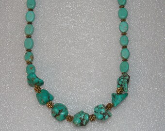 May include: A turquoise and gold necklace with oval and irregular shaped beads. The necklace is made of natural turquoise stones and gold-toned metal.