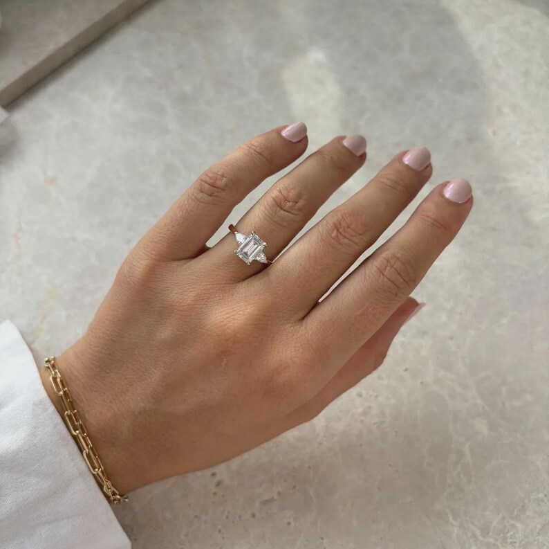 Anello di fidanzamento trilogy con diamante taglio smeraldo sintetico da 2 carati in oro bicolore. immagine 2