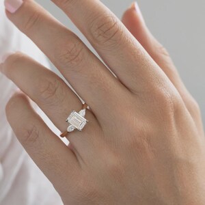 Anello di fidanzamento trilogy con diamante taglio smeraldo sintetico da 2 carati in oro bicolore. immagine 4