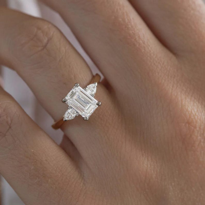 Anello di fidanzamento trilogy con diamante taglio smeraldo sintetico da 2 carati in oro bicolore. immagine 5