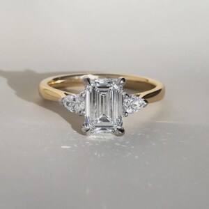Anello di fidanzamento trilogy con diamante taglio smeraldo sintetico da 2 carati in oro bicolore. immagine 6