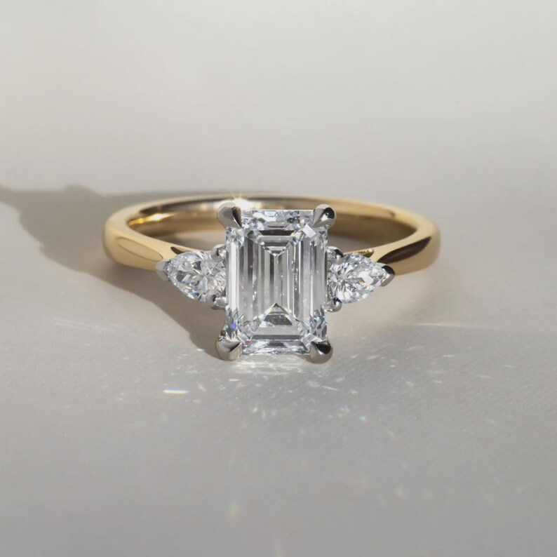 Anello di fidanzamento trilogy con diamante taglio smeraldo sintetico da 2 carati in oro bicolore. immagine 6