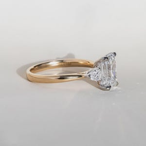 Anello di fidanzamento trilogy con diamante taglio smeraldo sintetico da 2 carati in oro bicolore. immagine 7