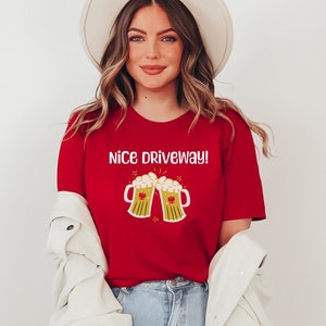 May include: Red t-shirt with a white graphic of two beer mugs clinking and the text "Nice Driveway!"
