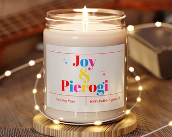 May include: A 9 oz soy wax candle with a white label that reads "Joy & Pierogi 100% Polish Approved". The candle is lit and sitting on a wooden coaster.