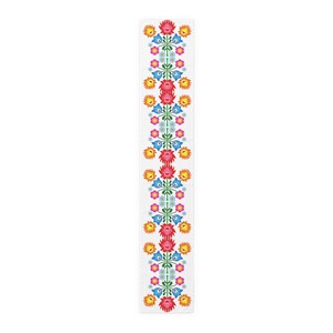 May include: A white table runner with a repeating pattern of colorful flowers. The flowers are red, orange, yellow, blue, and green. The pattern is symmetrical and creates a traditional folk art design.