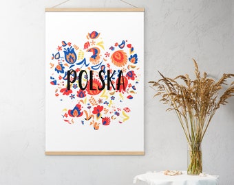 Peut inclure: Une affiche blanche avec un motif floral coloré en forme d'armoiries polonaises. Le mot "POLSKA" est écrit en lettres noires au centre du motif.