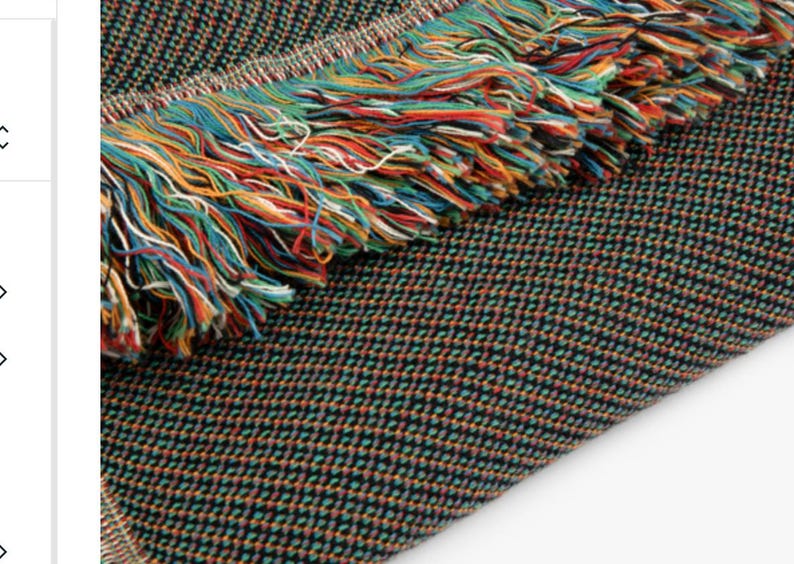 May include: A black and green woven throw blanket with a colorful fringe. The fringe is made of yarn in shades of red, orange, yellow, green, blue, and white.