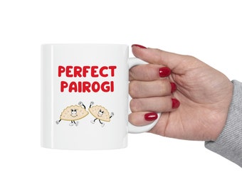 May include: White ceramic mug with a red graphic that says "PERFECT PAIROGI" and two cartoon pierogies with faces.