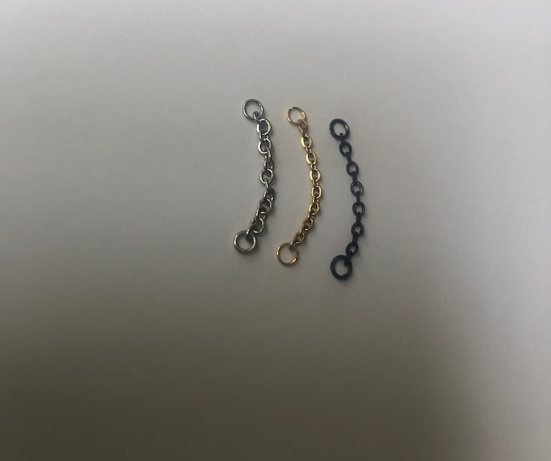K&ouml;nnte beinhalten: Drei silberne, goldene und schwarze Kettenverl&auml;ngerungen. Jede Verl&auml;ngerung ist etwa 5 cm lang und hat an jedem Ende eine Schlaufe.