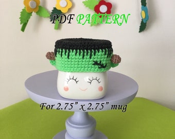 May include: Green and black crocheted mug cozy in the shape of Frankenstein's monster. The cozy is designed to fit a 2.75 inch by 2.75 inch mug. PDF PATTERN.