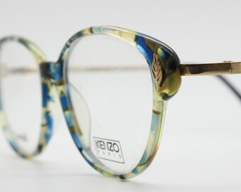 Kenzo 90s vintage cat eye glasses hand made in France. Transparent patterned optical frame with ornate arm details. Womens Prescription. NOS