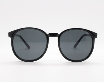 80s vintage black round sunglasses. Slightly oversized slim frame with dark lenses. Unworn NOS