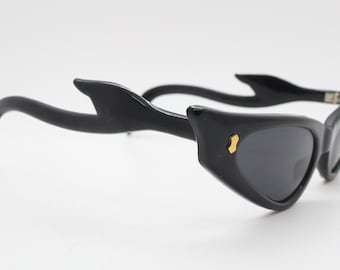Gafas de sol vintage de los años 80 con forma de ojo de gato y patillas flameadas espectaculares, con una montura negra fina. Estilo rockabilly pin-up de los años 50 para mujer. BNWT NOS.