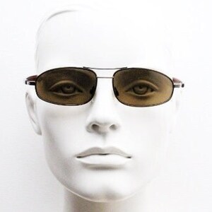 May include: A mannequin wearing a pair of brown aviator sunglasses with a silver frame.