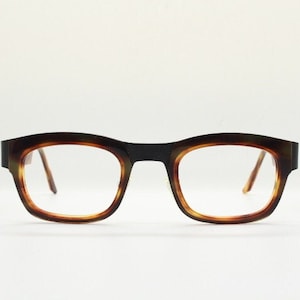 Könnte beinhalten: Schildpatt-Brille mit dunkelbraunem Gestell und klaren Gläsern.