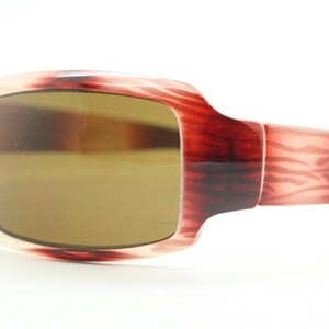 Puede incluir: Gafas de sol de carey rojo y blanco con lentes marrones.