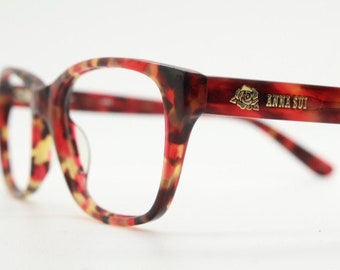 Modifizierte Brille im Wayfarer-Design von Anna Sui. Hervorragende optische Fassung aus marmoriertem Acetat mit Rottönen. RX-Vintage-Brille mit Sehstärke