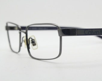 Lunettes de vue rectangulaires de la collection Calvin Klein modèle 582 fabriquées au Japon. Montures optiques en fil de fer gris bronze. Lunettes de vue correctrices. Réception