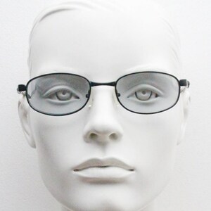 May include: A white mannequin head wearing black framed glasses with clear lenses.