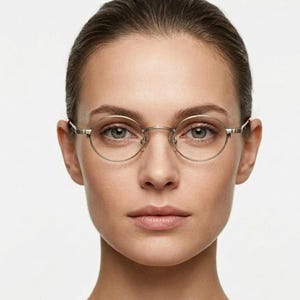 May include: Round spectacles with a thin, metallic gold frame featuring a textured bridge and slim temples. The lenses are clear and circular, framed by a delicate wire structure that rests on the bridge of the nose with small, transparent nose pads.