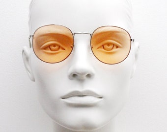 Occhiali da sole rotondi in metallo vintage anni '90, montatura argentata in stile anni '60 con lenti arancioni accese. Mai usati. Nuovi di zecca. Panto.