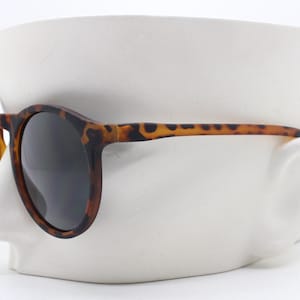 90s vintage round sunglasses. Classical 40s style keyhole bridge frame in a rubber finish with contrasting black lenses. Unused