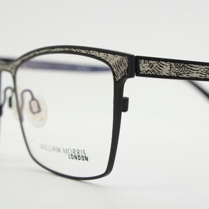 May include: Black rectangular eyeglasses with a silver patterned design on the arms. The brand name "William Morris London" is printed on the frame.