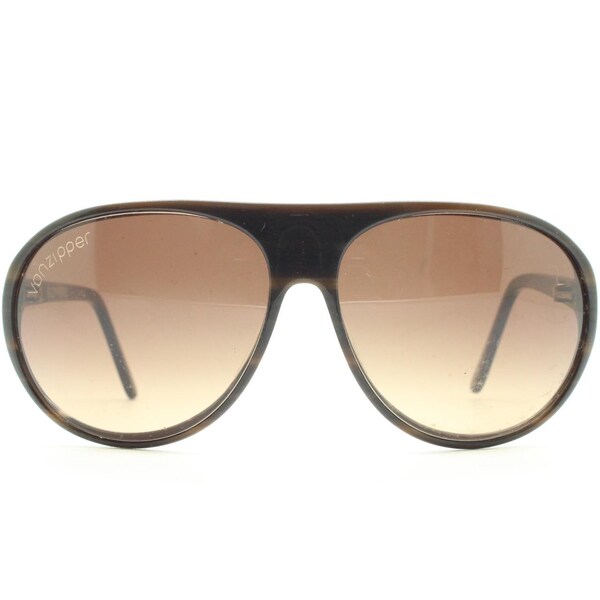 May include: Brown aviator sunglasses with gradient lenses. The sunglasses have a dark brown frame and the brand name "VonZipper" is printed on the left lens. The lenses transition from a light brown to a darker brown.