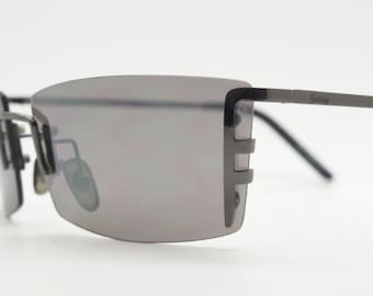 Y2K vintage wraparound sunglasses. Dynamic frameless shield design in gunmetal grey with slight mirror glaze rectangular lenses. 2000's NOS