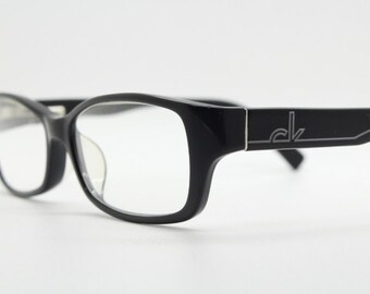 Lunettes de vue Calvin Klein rectangulaires modèle 5714. Monture discrète en acétate noir brillant. Lunettes de vue correctrices. Lunettes de vue vintage RX