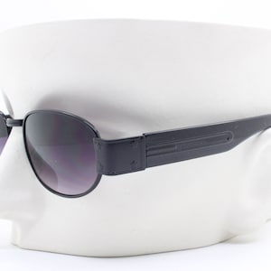 Lunettes de soleil vintage des années 90 à profil bas. Monture rectangulaire noire avec branches noires épaisses et verres dégradés. EBND inutilisés