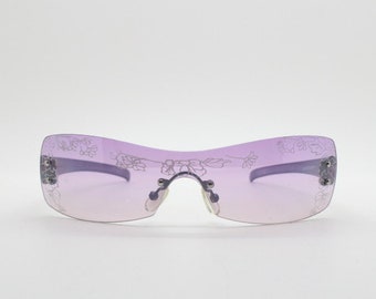 Lunettes de soleil à visière vintage Y2K. Conception de mini-masque enveloppant violet sans cadre des années 2000 avec lentille mono ton clair et imprimé fleuri. 00s NAI