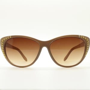 Occhiali da sole ovali vintage a forma di occhio di gatto, stile Y2K. Occhiali da sole a forma di occhio di gatto beige da donna degli anni 2000 con lenti sfumate color avana e borchie dorate agli angoli. Nuovi di zecca.