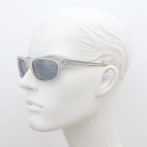 Dakota Smith vintage 90s futuristic sunglasses. Transparent frosted wrap around shield frame with mirror lenses and ornate arm patterns