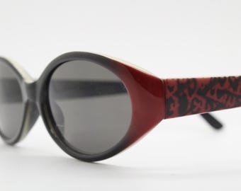 Vintage 90s oval sunglasses with very unique abstract arm pattern in black and red on layered acetate. Authentic original design. NOS