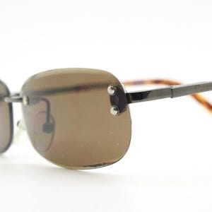 90s vintage minimal frameless sunglasses. Minimal brown rectangular lens with bevelled edges, gunmetal grey trim and tortoise arms. NOS