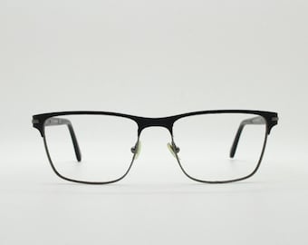 Lunettes de vue rectangulaires Calvin Klein. Monture en fil de fer chromé gris bronze avec arcade sourcilière noire mate. Lunettes de vue correctrices. Lunettes de soleil RX