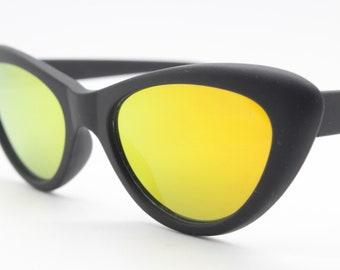 Gafas de sol vintage de los 90 con forma de ojo de gato ovaladas. Montura de ojo de gato negra con acabado de goma y lentes doradas de espejo. Estilo rockabilly. Sin usar.