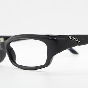 May include: Black plastic framed spectacles with clear lenses. The brand name "MISSONI" is printed on the right temple.